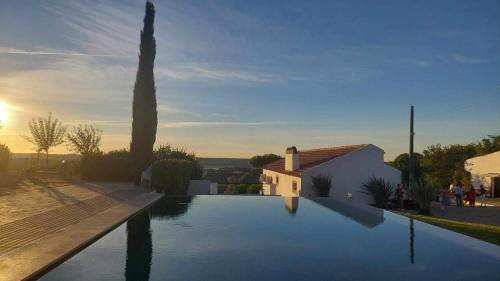 a swimming pool in front of a house at Herdade da Fonte Ferreira in Avis