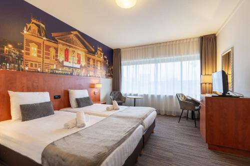 una camera d'albergo con due letti e una televisione di New West Inn Amsterdam ad Amsterdam