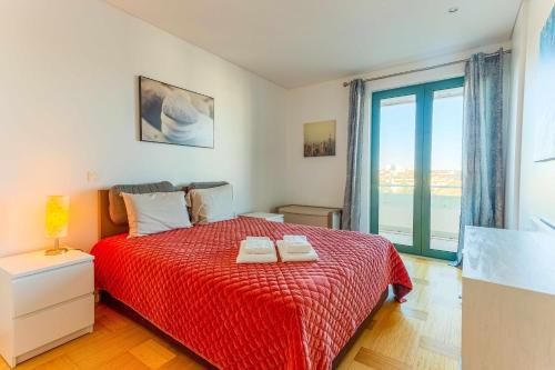 ヴィラモウラにあるVilamouraSun Aquamar 518 Fantástico Vistaのベッドルーム1室(赤いベッド1台、タオル2枚付)