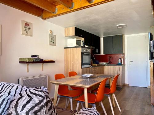 une cuisine avec une table et des chaises dans une pièce dans l'établissement Pavillon à 150m de la plage, 5 couchages - FR-1-336-37, à Longeville-sur-Mer