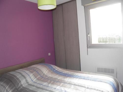 une chambre avec un lit aux murs violets et une fenêtre dans l'établissement Appartement 2 pièces, tennis, parking, proche plage - FR-1-338-13, à Sète