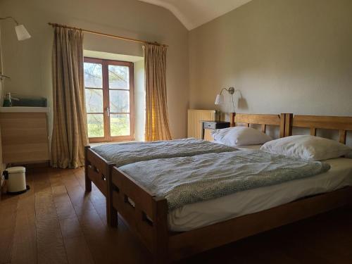 Un dormitorio con una cama grande y una ventana en Lovely holiday home in Orval with garden en Florenville