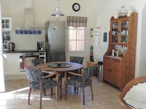 une cuisine avec une table, des chaises et un réfrigérateur dans l'établissement House in Buisson with Provencal Charm, à Buisson