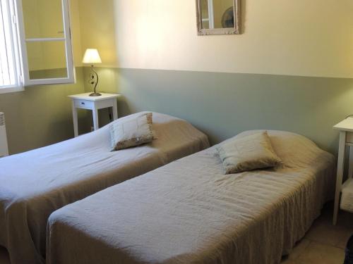 une chambre avec deux lits et une lampe et une fenêtre dans l'établissement House in Buisson with Provencal Charm, à Buisson