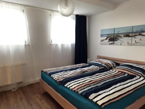 Un dormitorio con una cama con una manta a rayas. en Family Escape in Lichtenau, en Oberlichtenau
