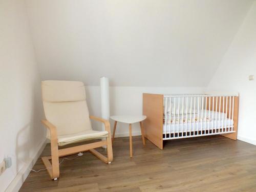 Habitación para bebés con silla y cuna en Family Escape in Lichtenau, en Oberlichtenau
