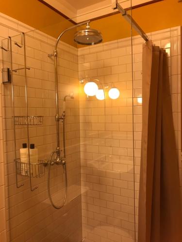 a bathroom with a shower with a glass door at Ombergs Turisthotell in Ödeshög