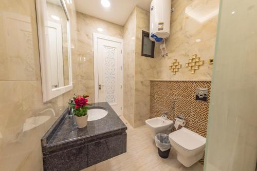 a bathroom with a white toilet and a sink and a sink at Adam's Luxury Villa DeadSea in Sowayma