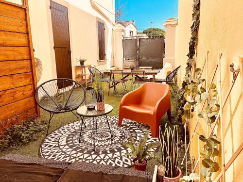 een patio met stoelen en een tafel en stoelen bij La Villa Camille in Hyères