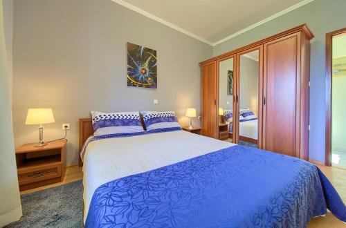 um quarto com uma grande cama azul e um espelho em Apartments Mira em Porat
