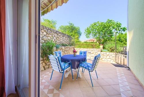een tafel en stoelen op een patio met een stenen muur bij Apartments Mira in Porat