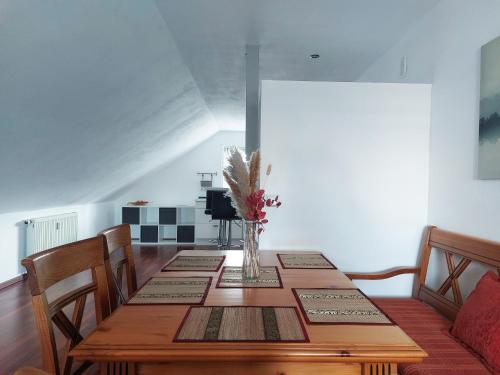a dining room table with a vase of flowers on it at Sonnige Ferienwohnung bei Familie Köhler in Kappel-Grafenhausen