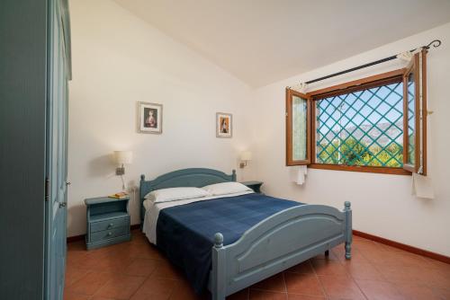a bedroom with a bed and a window at Su Cannonariu in Orosei