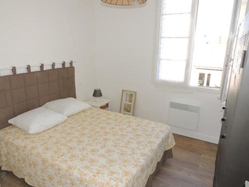 ein Schlafzimmer mit einem Bett und zwei Fenstern in der Unterkunft Appartement Royan, 3 pièces, 5 personnes - FR-1-71-51 in Royan