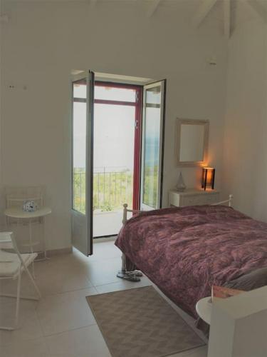 a bedroom with a bed and a large window at Seaview lovely Villa in Leonidio