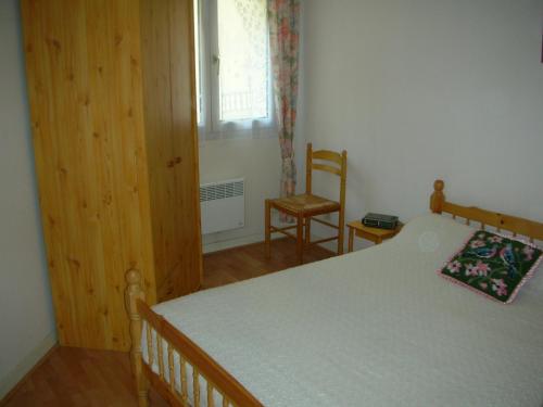 une chambre avec un lit, une chaise et une fenêtre dans l'établissement Appartement T2 à 100m du marché central et 500m de la plage à Royan - FR-1-71-53, à Royan