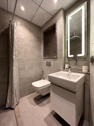 uma casa de banho com um lavatório e um WC em 21st Floor SkyStudio Suite with Balcony em Nova Deli