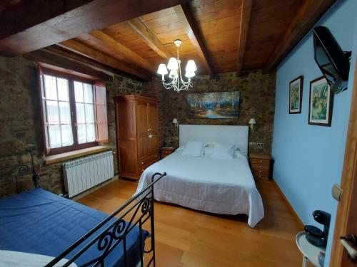 - une chambre avec un lit et un lustre dans l'établissement Hotel Rural El Angel de la Guarda, à Güemes