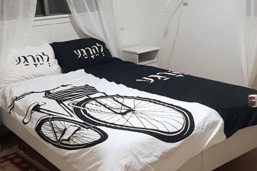 een bed met een fiets gedrukt op de lakens bij A beautiful bright unit with a large front yard. in ‘Ilūṭ