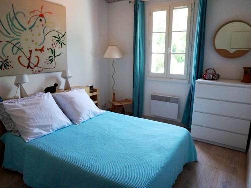濱海拉庫阿爾德的住宿－Villa La Couarde-sur-Mer, 6 pièces, 6 personnes - FR-1-258-98，一间卧室配有一张带蓝色床单的床和一扇窗户。