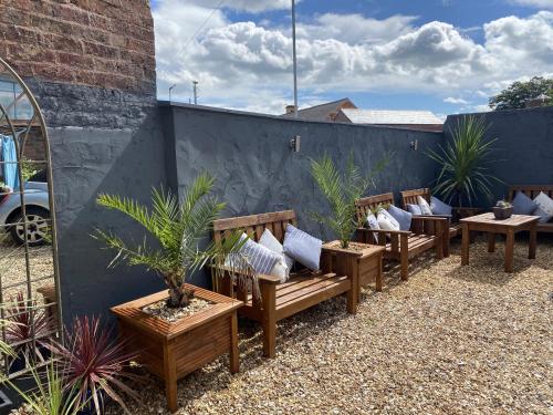 eine Reihe von Bänken mit Kissen auf einer Terrasse in der Unterkunft Maison Claire in Chester