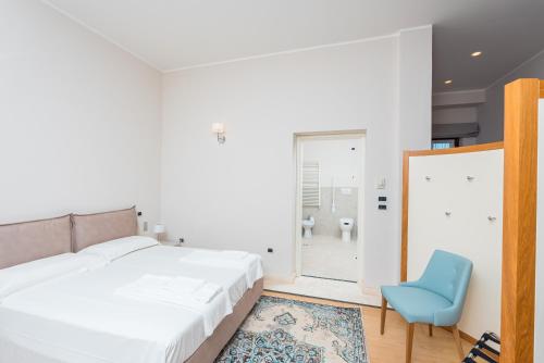 a bedroom with a bed and a blue chair at Fattoria Colsanto in Torre del Colle