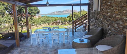 a patio with a table and chairs and a view of the ocean at Villa Boat - in front of the Sea in Stintino