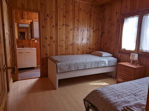 1 dormitorio con 2 camas en una cabaña de madera en Bungalow con piscina en camping privado cerca de la playa de Torre del Mar Ideal familias en Vélez-Málaga