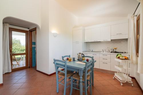 a kitchen with a blue table and chairs at Su Cannonariu in Orosei