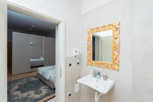 baño con lavabo, espejo y cama en Fattoria Colsanto, en Torre del Colle