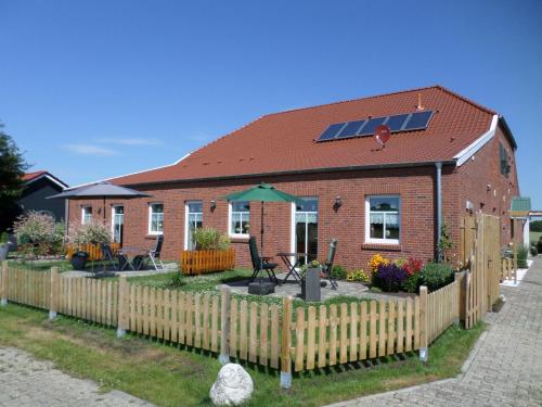 a house with a fence and a solar roof at Haus Sonnenhof am Dollart 45240 in Ditzumerhammrich