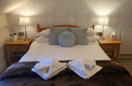 a bedroom with a bed with white sheets and pillows at Sonas Guesthouse in Edinburgh