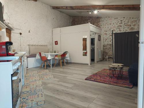 a living room with a table and a kitchen at Ancienne grange rénovée in Tuchan