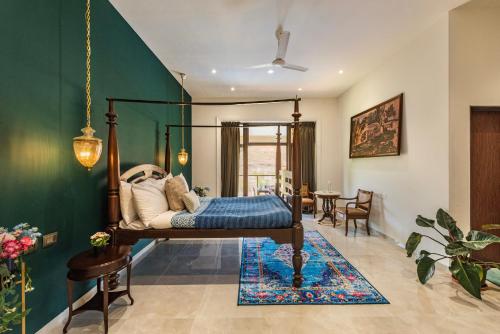 a bedroom with a bed and a green wall at SaffronStays Zuma Villa, Pawna - luxury villa with a heated pool, sports court and gym in Malavli
