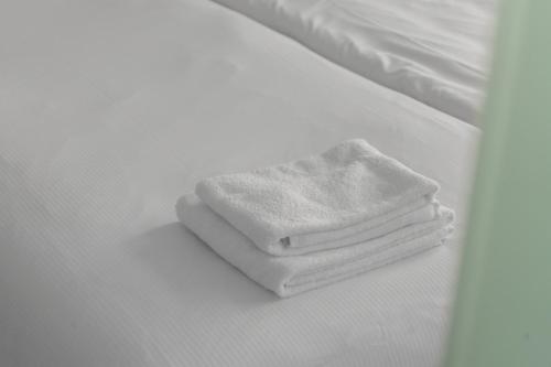 a stack of white towels sitting on a bed at Hotel de la Bourse in Maastricht