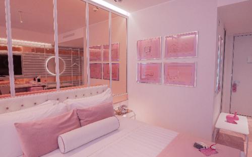 a bedroom with a bed with pink pillows and a mirror at ODSweet Duomo Milano Hotel in Milan
