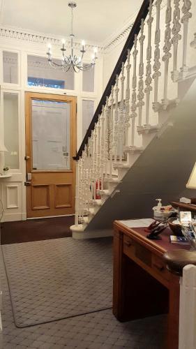 a staircase in a house with a table and a window at Sonas Guesthouse in Edinburgh