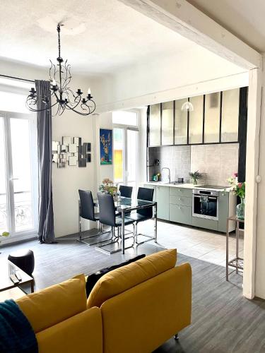 un salon avec un canapé jaune et une table dans l'établissement CÔTE D’AZUR Appart spacieux / lumineux, à Toulon