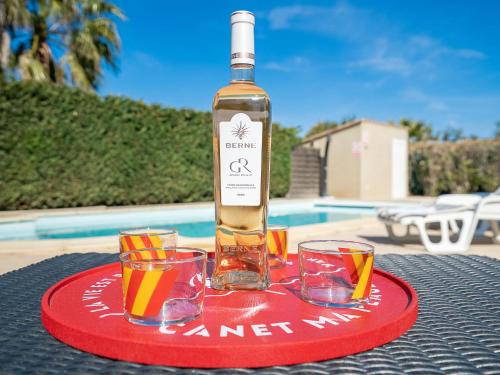 a bottle of wine and two glasses on a table at Villa Les Villas de l'Etang by Interhome in Canet-en-Roussillon
