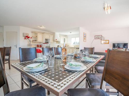 un comedor con una mesa con platos y vasos en Villa Les Villas de l'Etang by Interhome, en Canet-en-Roussillon