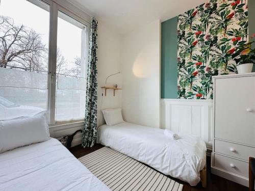 mała sypialnia z dwoma łóżkami i oknem w obiekcie Le jardin secret - Jardin/Loire w Tours