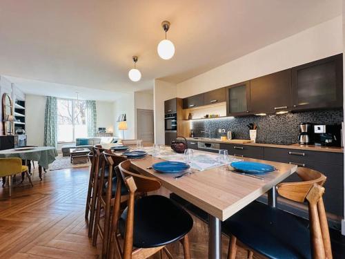 une cuisine avec une grande table et des chaises en bois dans l'établissement Le jardin secret - Jardin/Loire, à Tours