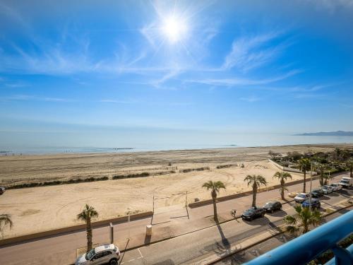 - une vue sur un parking avec des palmiers et la plage dans l'établissement Apartment Marianne by Interhome, à Canet