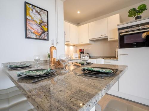 une cuisine avec un comptoir en marbre avec des verres et des assiettes dans l'établissement Apartment Le Beaupré-21 by Interhome, à Canet