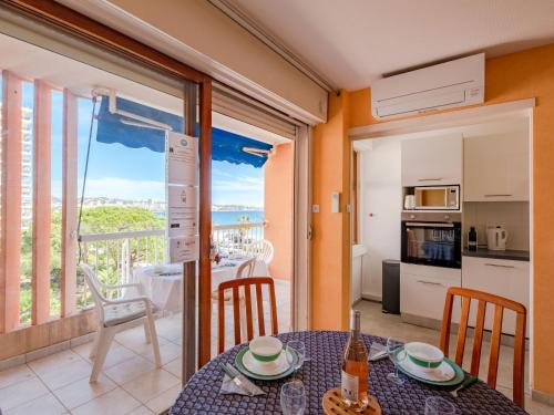 uma sala de jantar com uma mesa e uma cozinha com uma varanda em Apartment Le Méditerranée-1 by Interhome em Fréjus