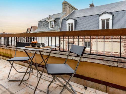 une table et deux chaises assises sur un balcon dans l'établissement Apartment Les Cigognes by Interhome, à Deauville
