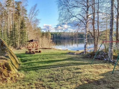 un parque con parque infantil junto a un lago en Holiday Home Sanninpirtti by Interhome en Niskamäki