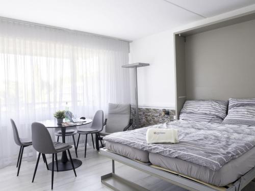 1 dormitorio con 1 cama, mesa y sillas en Apartment Lago di Lugano-5 by Interhome, en Bissone