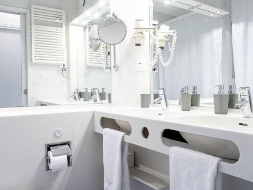 a white bathroom with a sink and a mirror at Apartment Lakeview App- 214 by Interhome in Bissone