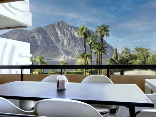 a table and chairs with a view of a mountain at Apartment Lakeview App- 214 by Interhome in Bissone